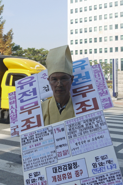 김기학 택시정책연구소장이 3일 낮 대전지검 정문 앞에서 도급택시를 행정처분하지 않은 공무원에 대한 고발을 행정소송 사안이라며 기각한 검찰을 규탄하는 1인 시위를 하고 있다. 그는 도급택시가 늘어나 택시운전 종사자들의 처우가 악화되고 있는데도 대전시와 검찰이 수수방관하고 있다고 비판했다.  
 송인걸 기자 <A href="mailto:igsong@hani.co.kr">igsong@hani.co.kr</A> 