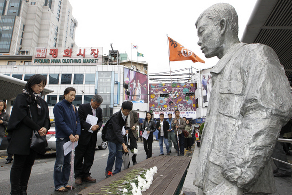 전태일 열사 41주기를 일주일 앞둔 6일 오후 서울 청계6가 ‘전태일 다리’에서 향린교회 교인들이 추도 기도회를 연 뒤 전태일 동상에 헌화하고 있다. 김정효 기자 hyopd@hani.co.kr