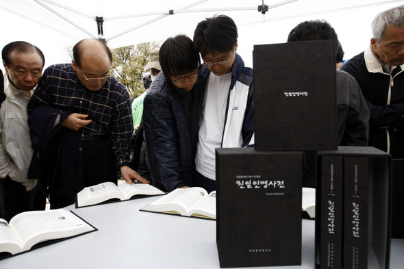 ‘친일인명사전발간 국민보고대회’가 열린 2009년 11월 행사 참가자들이 서울 용산구 효창동 백범 김구 묘역에서 사전에 실린 친일 인사들의 명단을 살펴보고 있다.  김명진 기자 littleprince@hani.co.kr