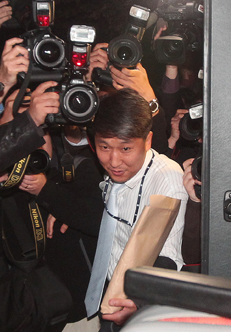  한 검찰 수사관이 최태원 에스케이(SK)그룹 회장의 회삿돈 횡령 의혹 수사를 위해 8일 오전 서울 종로구 서린동 에스케이 본사를 압수수색한 뒤 서류 봉투를 들고 검찰 버스에 오르고 있다. 신소영 기자 <A href="mailto:viator@hani.co.kr">viator@hani.co.kr</A>