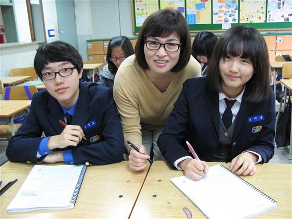 통합논술세미나 수업을 진행하는 이현숙(가운데) 방과후학교 강사가 인천 구산중 학생들한테 글쓰기 지도를 해주고 있다.