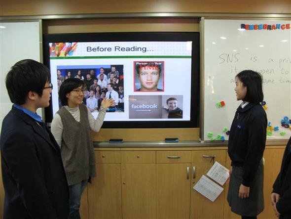 인천 구산중 학생들과 이미경(가운데) 방과후학교 강사가 뉴스인잉글리시 수업 뒤 시청각 자료를 보며 이야기를 나누고 있다.