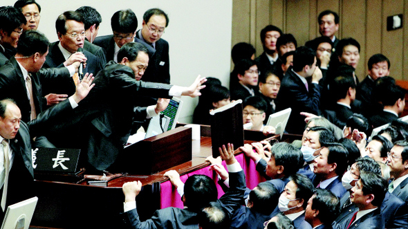 22일 오후 국회 본회의장에서 정의화 국회 부의장(왼쪽 위 마이크 든 이)이 기습적으로 한-미 자유무역협정(FTA) 비준동의안을 통과시키려고 하자, 한 야당 의원이 의사봉 받침대를 던지려 하는 등 민주당과 민주노동당 의원들이 거세게 항의하고 있다. 김명진 기자 <A href="mailto:littleprince@hani.co.kr">littleprince@hani.co.kr</A>