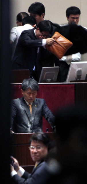 22일 오후 국회 본회의장에서 김선동 민주노동당 의원(가운데)이 정의화 국회부의장에게 최루가루를 뿌린 뒤 눈을 감은채 고개를 숙이고 있다.  이정우 선임기자 woo@hani.co.kr