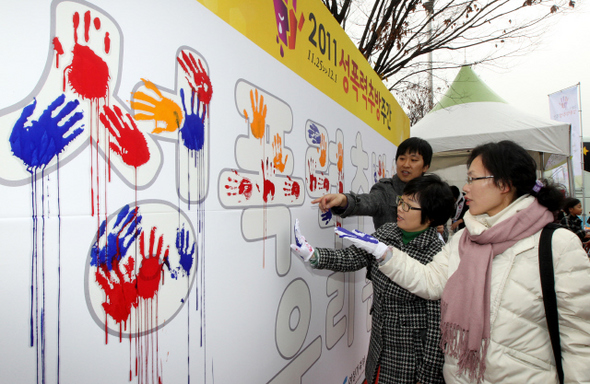  제1회 성폭력추방주간을 맞아 여성가족부가 27일 낮 서울 여의도공원에서 연 ‘찾아가는 거리 성교육’ 행사중 시민들이 ‘성폭력 추방 우리 손으로’라는 문구가 새겨진 벽에 핸드프린팅을 남기고 있다. 강재훈 선임기자 khan@hani.co.kr