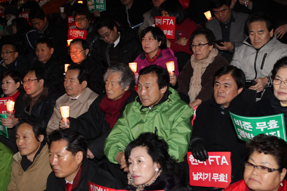 26일 오후 촛불집회에 참석한 손학규 민주당 대표, 이정희 민주노동당 대표, 백기완 선생 등이 세종문화회관 앞 계단에 앉아 있다.