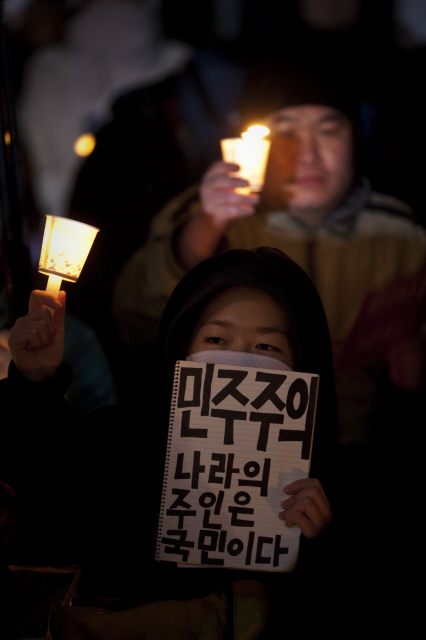 지난 28일 서울 종로구 세종문화회관 앞에서 열린 ‘한-미 자유무역협정(FTA) 무효 촉구 촛불집회’에 참석한 한 시민이 ‘민주주의’라고 쓴 손팻말을 들고 있다. <한국 신자유주의의 기원과 형성>을 쓴 지주형씨는 “한-미 자유무역협정이 적나라하게 보여주듯 한국에서 ‘신자유주의’는 소수 지배층이 주도해 민중의 참여를 배제하고 추진됐다”며 “결국 민주주의의 문제로 연결된다”고 지적했다.  박승화 <한겨레21> 기자 eyeshot@hani.co.kr