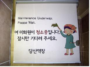 지하철 남자화장실 입구 벽에 붙은 ’청소중’ 안내 표시.