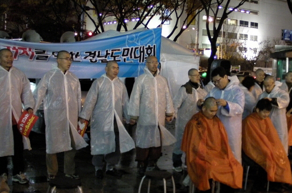 경남지역 시민사회단체 대표와 학부모 등 20여명이 지난달 30일 창원시 정우상가 앞에서 열린 ‘고입 연합고사 저지를 위한 경남도민대회’에 참석해 경남도교육청의 고입 연합고사 부활 방침에 항의하는 뜻으로 삭발하고 있다.  전국교직원노동조합 경남지부 제공