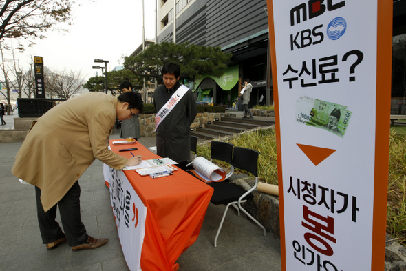  6일 한국케이블티브이방송협회가 주최한 ‘지상파 유료화 반대’를 위한 서명운동이 열린 서울 세종로 방송통신위원회 앞에서 한 시민이 서명을 하고 있다.  김명진 기자 littleprince@hani.co.kr