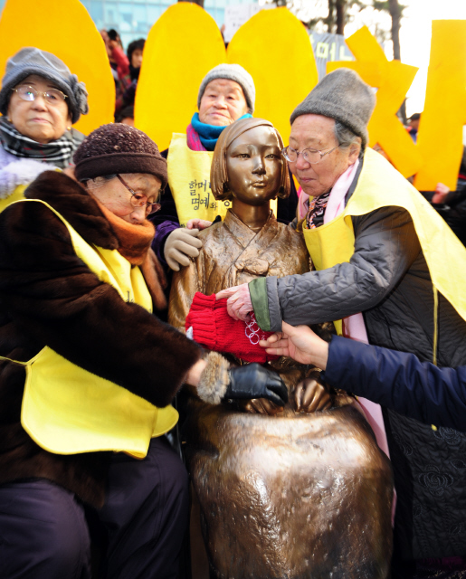 일본군 ‘위안부’ 피해 할머니들이 14일 오후 ‘일본군 위안부 문제 해결을 위한 1000번째 정기 수요시위’가 열린 서울 종로구 중학동 일본대사관 앞에서 ‘평화의 비’를 만져 보고 있다. 이 비석은 120㎝의 소녀상과 빈 의자가 일본대사관을 마주 보게끔 설치됐다. 공동취재사진