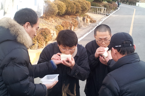 송경동 시인(왼쪽에서 두번째)과 정진우 진보신당 비정규직 노동실장이 9일 오후 부산구치소에서 출소해 축하행사로 지지자들이 준비해온 두부를 먹고 있다. 사진 트위터 이용자 @ahb174488