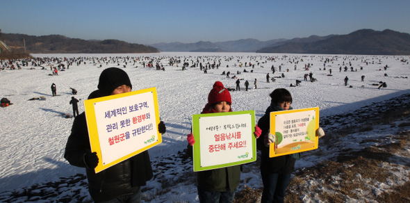 녹색연합 활동가들이 12일 오전 국내 최대 두루미 도래지인 강원도 철원군 동송읍 토교저수지에서 얼음낚시대회를 반대하는 손팻말을 들고 시위를 벌이고 있다. 이들은 “두루미와 고니, 독수리 등 각종 겨울 철새가 월동하고 있는 지역에서 1000명 이상 모이는 얼음낚시를 하도록 한 것 자체가 비상식적”이라며 “한꺼번에 많은 사람이 몰리면 새들이 스트레스를 받을 수 밖에 없다”고 말했다. 철원/박종식 기자 anaki@hani.co.kr
