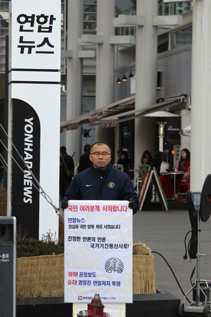 <연합뉴스> 공병설 노조위원장이 지난 15일 오후 서울 중구 연합뉴스 사옥 앞에서 "국민 여러분께 사죄합니다. 연합뉴스, 진실과 국민 앞에 바로 서겠습니다. 쟁취! 공정보도. 승리! 경영진 연임 저지투쟁" 등의 글이 적힌 손팻말을 들고 1인시위를 벌이고 있다. 류우종 기자 wjryu@hani.co.kr