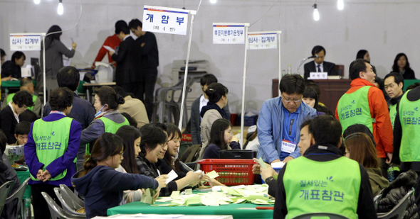 제19대 국회의원 선거 개표가 실시된 11일 저녁 서울 종로구 경기상고 체육관에서 개표사무원들이 투표함을 열고 개표 작업을 하고 있다.  김봉규 기자 bong9@hani.co.kr