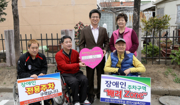 지난 13일 대전 유성구 구암동 삼오빌라에 장애인 거주지 우선주차구역 ‘배려존’이 만들어진 뒤 허태정 구청장과 중증장애인들이 환하게 웃고 있다.  유성구 제공