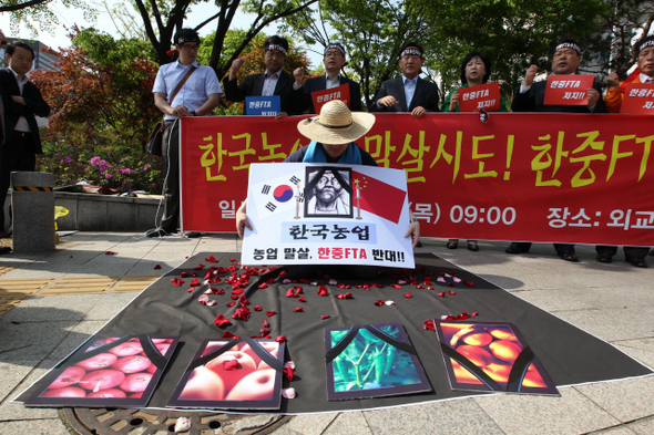 농수축산연합회 회원들이 3일 오전 서울 세종로 외교통상부 앞에서 ‘한-중 자유무역협정(FTA) 협상 개시 규탄 기자회견’을 열고 농민들의 고통을 표현한 행위극을 하고 있다.  박종식 기자 anaki@hani.co.kr