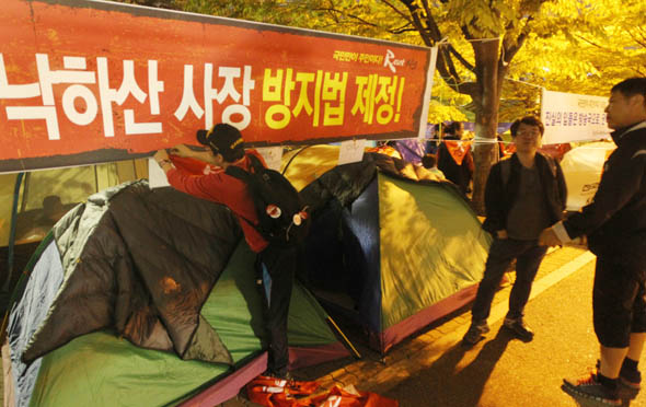 문화방송 노조 파업 100일을 하루 앞두고 문화방송과 한국방송 새노조가 서울 여의도공원에서 텐트 노숙투쟁에 들어간 7일 밤, 한 노조원이 펼침막에 소속 분회 이름을 표시하고 있다.  이정우 선임기자 <A href="mailto:woo@hani.co.kr">woo@hani.co.kr</A>