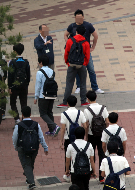 서울의 한 고등학교 교사가 지난 17일 학교 정문에서 등교하는 학생들의 두발과 복장 등을 점검하는 ‘교문 지도’를 하고 있다. 김태형 기자 <A href="mailto:xogud555@hani.co.kr">xogud555@hani.co.kr</A>