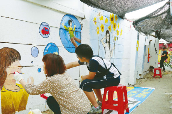 지난 19일 주말에 재능나눔 자원봉사에 나선 중·고등학생들이 경기도 고양시 일산서구 일산1동 골목길 콘크리트 담벽에 그림을 그리고 있다.