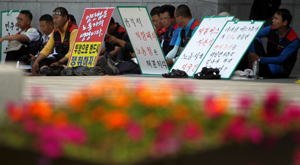 전주 시내버스 5개사 노조원들이 지난달 29일 집단 릴레이 단식농성 기자회견을 끝낸 뒤 시청사 앞에 펼침막을 들고 앉아 있다.  전주/강재훈 선임기자 <A href="mailto:khan@hani.co.kr">khan@hani.co.kr</A>