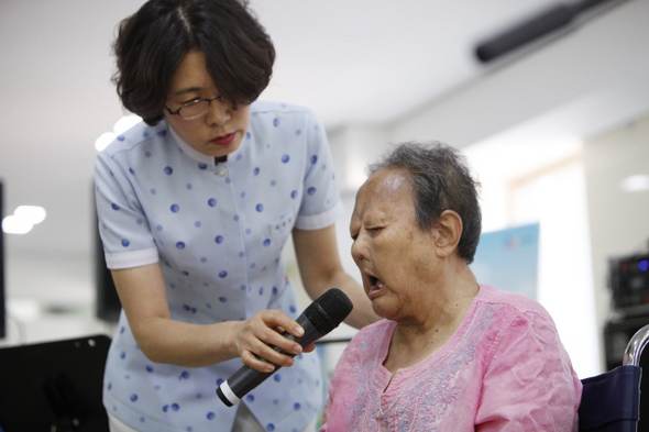 한센병 환자인 김용덕 할머니(오른쪽)가 자신을 돌봐주는 허옥희 간호사(왼쪽)에게 고마움을 전하려고 손수 노랫말을 바꾼 ‘황성옛터’를 부르는 모습. 씨제이문화재단 제공