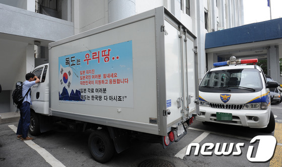 소녀상(평화비)에 '타케시마는 일본땅'이라는 말뚝을 설치한 데 격분한 화물차량 운전수가 자신의 차를 몰고 일본대사관 정문으로 돌진한 9일 오전 서울 종로경찰서에 '독도는 우리땅'이라는 글귀가 적힌 사고차량을 한 시민이 들여다보고 있다. 경찰은 "화물차량이 일본대사관 정문을 1m가량 밀고 들어가면서 철재문이 훼손됐지만 인명피해는 없었다"고 전했다. 서울=뉴스1
