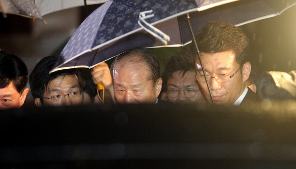 저축은행과 코오롱그룹 등에서 수억원을 받은 혐의로 구속된 이상득 전 새누리당 의원(가운데)이 11일 새벽 서울 서초구 대검찰청을 나와 구치소로 가기 위해 차에 타고 있다.  신소영 기자 viator@hani.co.kr