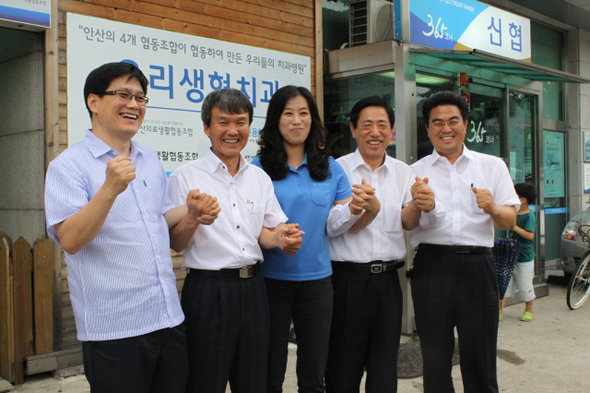 1990년 안산소비자협동조합 설립 때부터 함께 활동하며 지금의 화랑신협을 일궈온 주인공들이 10일 안산시 고잔1동 화랑신협 건물 앞에서 손을 잡았다. 오른쪽부터 임준용 전무, 김상열 이사장, 손금화 상무, 주영덕 감사실장이고, 임선재 초대 이사장은 병환중이어서 함께하지 못했다. 맨 왼쪽은 안산사회복지사협회 장지훈 사무국장.