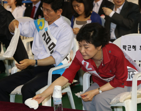 박근혜 새누리당 대선 경선 후보가 2일 오후 충남 천안 유관순체육관에서 열린 대전·세종·충북·충남 합동연설회에서 연설을 하기에 앞서 물수건을 집고 있다. 왼쪽은 이날 공천헌금 의혹 관련, 박근혜 책임론을 제기한 김문수 경기지사. 천안/강창광 기자 chang@hani.co.kr