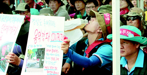 7일 오전 경기도 안산 반월공단 에스제이엠(SJM) 사옥 앞에서 지난달 용역경비업체를 고용해 폭력사건을 일으킨 회사 쪽을 규탄하는 노조 집회가 진행되는 도중 한 조합원이 물을 마시고 있다.  안산/신소영 기자 viator@hani.co.kr