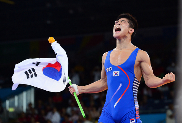 김현우가 8일 새벽(한국시각) 런던올림픽 레슬링 그레코로만형 66㎏급에서 금메달을 딴 뒤 태극기를 든 채 포효하고 있다.  런던/올림픽사진공동취재단