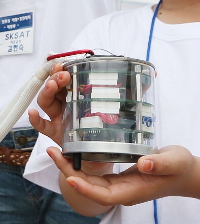 9일 세종시 행정중심복합도시건설청 근처에서 카이스트(KAIST) 인공위성연구센터 주관으로 열린 ‘2012 캔위성 체험·경연대회’에서 서울 신광초등학교 학생들로 짜인 ‘SKSAT’팀이 자신들이 만든 캔위성을 내보이며 활짝 웃고 있다. 카이스트 제공