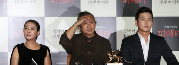 <피에타>의 김기덕 감독(가운데)이 11일 오후 서울 중구 메가박스 동대문에서 열린 ‘제69회 베네치아(베니스) 국제영화제’ 황금사자상 수상 기념 기자회견에서 이마에 손을 올려 취재기자의 질문에 집중하고 있다. 왼쪽은 조민수씨, 오른쪽은 이정진씨. 이정아 기자 leej@hani.co.kr