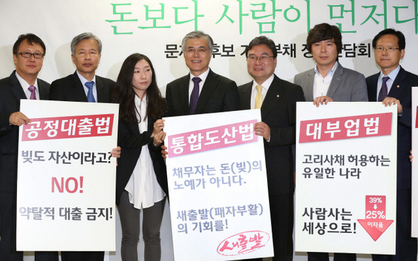 문재인 민주통합당 대통령후보가 16일 오후 서울 여의도 시민캠프에서 가계부채 정책간담회를 하기에 앞서 참석자들과 함께 준비중인 법률안이 담긴 팻말을 들어 보이고 있다.   이정우 선임기자 woo@hani.co.kr
