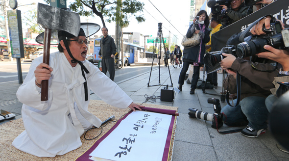 조선시대 유생 복장을 한 이건범 한글문화연대 상임대표가 23일 오전 서울 대흥동 경총회관 앞에서 한글날 공휴일 추진에 반대하는 한국경영자총협회의 입장 철회를 요구하며 임금에게 상소를 올리는 행위극을 하고 있다. 이 대표가 들고 있는 도끼 모형은 조선시대 한글 반포와 사용에 반대하며 유생들이 목숨 걸고 상소했던 ‘도끼 상소’ 사건을 역설적으로 빗대 준비한 것이다. 
김정효 기자 <A href="mailto:hyopd@hani.co.kr">hyopd@hani.co.kr</A>