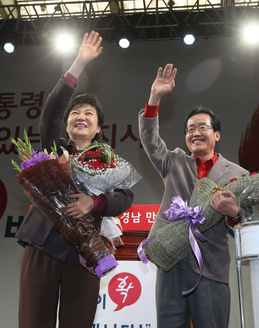 새누리당 박근혜 대선 후보(왼쪽)가 16일 오후 경남 창원시 마산회원구 양덕동 마산실내체육관에서 열린 ‘도민과 함께 희망 경남 만들기’에 참석해 홍준표 경남도지사 후보와 함께 꽃다발을 들고 지지자들을 향해 손을 흔들고 있다.  창원/신소영 기자 viator@hani.co.kr