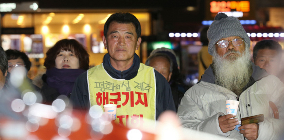 해군기지 건설 반대운동을 벌이고 있는 강동균(왼쪽) 제주 강정마을 회장이 20일 밤 서울 중구 대한문 옆 ‘함께살자 농성촌’에서 촛불을 들고 있다.   
 류우종 기자 wjryu@hani.co.kr