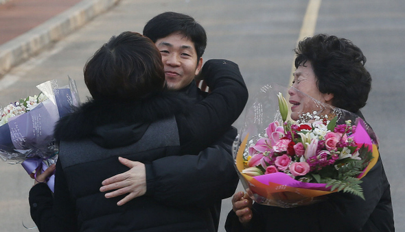 이충연 서울 용산4구역 철거민대책위원장이 31일 오전 경기도 안양시 호계동 안양교도소에서 특별사면으로 출소한 뒤 아내 정영신씨를 부둥켜안고 있다. 옆에는 어머니 전재숙씨가 꽃다발을 든 채 울먹이고 있다.  안양/신소영 기자 viator@hani.co.kr