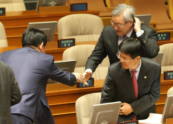 대통령직 인수위가 추진중인 외교통상부와 통상교섭본부를 분리하는 정부조직법 개정안에 반대 의사를 밝힌 김성환 외교통상부 장관이 5일 오전 국회 본회의에 출석해 최경환 새누리당 의원과 인사하며 머리를 긁적이고 있다.  이정우 선임기자 woo@hani.co.kr