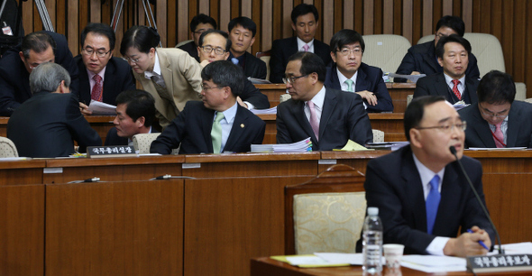 정홍원 국무총리 후보자가 21일 오전 국회에서 열린 이틀째 인사청문회에서 여야 위원들의 질의에 답하는 동안 배석한 임종룡 국무총리실장(정 후보자 뒷줄 맨 왼쪽) 등 직원들이 답변내용을 상의하고 있다.  강창광 기자 chang@hani.co.kr