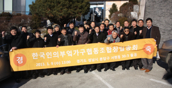 한국인의부엌가구 협동조합의 조합원들이 1월9일 경기도 성남시 분당의 한 음식점에서 창립총회를 마친 뒤 구호를 외치고 있다. 펼침막의 ‘협동조합’ 글자 바로 뒤에 선 이가 오영선 이사장이다. ‘한국인의 부엌가구’(케이쿱) 제공