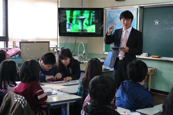 지난 7일, 부산 서명초등학교에서 아이패드를 이용한 미술수업이 진행되고 있다. 자폐증상이 있는 승하군은 황두점 특수교육실무원의 도움을 받아 수업에 참여했다. 아래 사진은 승하군이 애플리케이션을 이용해 직접 도자기를 만드는 모습. 