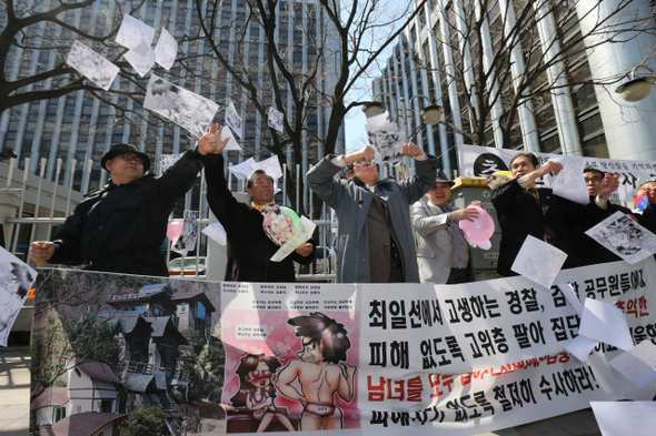 25일 오후 서울 서대문구 미근동 경찰청 앞에서 애국국민운동대연합 회원들이 고위층 성접대 의혹 관련자에 대한 철저한 수사를 촉구하는 기자회견을 마친 뒤 유인물을 뿌리는 거리행위극을 벌이고 있다.  김태형 기자 xogud555@hani.co.kr