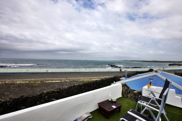 The road along the coast of Jeju Island, as seen from Woljeong Village. Over the last few years, about ten new guesthouses and cafes have been opened in the village by new residents from the mainland. (by Kim Myung-jin, Hankyoreh 21 photographer)