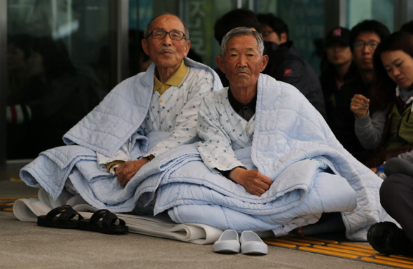 진주의료원에 입원중인 안우용(91·왼쪽), 이갑상(79) 할아버지가 6일 오후 경남 진주시 초전동 진주의료원 앞에서 열린 진주의료원 지킴이 발족식에 참석해 생명버스 참가자들의 발언을 듣고 있다. 진주/박종식 기자