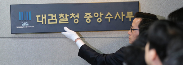 23일 오후 서울 서초동 대검찰청 중앙수사부 앞에서 박유수 대검 관리과장이 중수부 현판을 내리고 있다. 박종식 기자 anaki@hani.co.kr