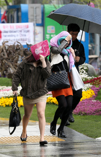 갑작스레 비가 내린 2일 오후 서울 광화문에서 미처 우산을 준비 못 한 시민들이 스카프 등으로 비를 가리며 발길을 재촉하고 있다.
 김정효 기자 hyopd@hani.co.kr