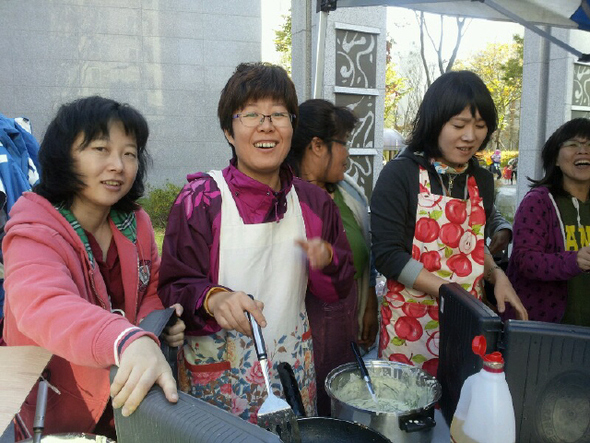 지난해 10월22일 서울 양천구 신정동 이펜하우스 3단지 안 관리사무소 앞 분수광장에서 작은도서관 ‘나무그늘’ 주최로 음식나눔행사를 열고 있는 도서관 주민 자원봉사자들의 모습.  나무그늘 제공
