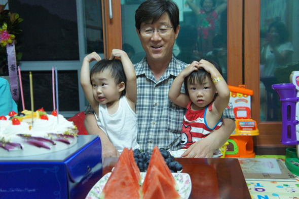 경찰관 퇴직후 손자·손녀들을 키우며 느낀 소회를 산문집으로 펴낸 신상채씨가 외손자(왼쪽)와 친손녀를 안고 있다. 신상채씨 제공.